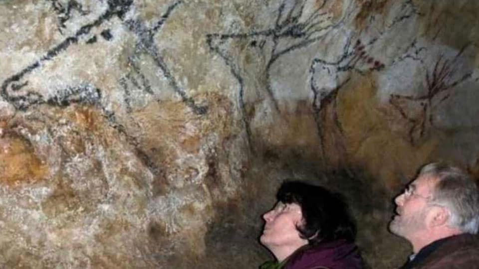 Couple viewing the drawings in Lascaux cave