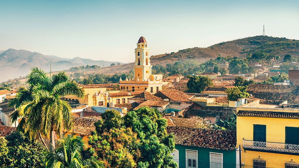 Panoramic view over the city of Trinidad, Cuba, with mountains in the background and a cloudy sky