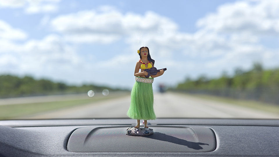 Hula dancer on the dashboard with the open road